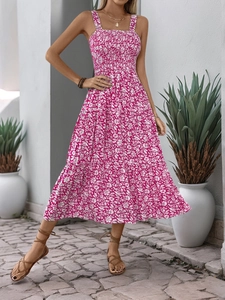 Detail of smocked bodice and tiered floral print hem on a rose red summer maxi dress