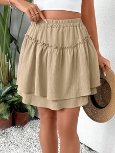 Close-up of khaki tiered mini skirt with elastic high waist and ruffled hem design