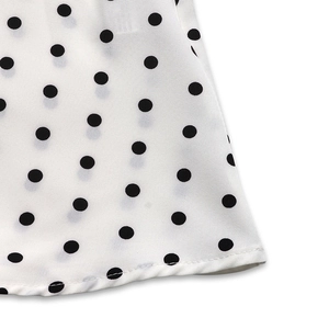 Close-up of white summer dress hem featuring black polka dot pattern and neat stitching