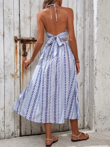 Détail d'une robe midi dos nu à licou avec motifs bleus et nœud papillon au dos