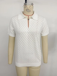 Vue détaillée du polo en tricot ajouré blanc montrant le motif de losanges et la texture