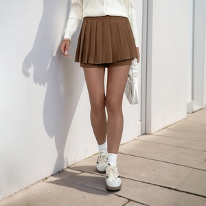 Brown high-waisted corduroy pleated mini skirt in a casual outdoor setting for women