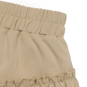 Detail of elastic waist and layered ruffle stitching on beige summer skirt fabric