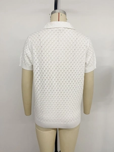 Détail d'un polo blanc en maille à manches courtes avec texture ajourée et ourlet côtelé