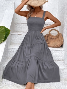 Detail of grey summer sundress featuring a smocked bodice and tiered ruffled hemline