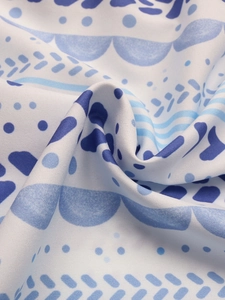 Gros plan d'un tissu à imprimé géométrique bleu montrant le drapé et la texture douce