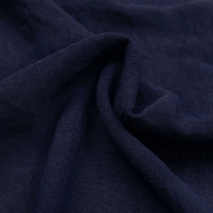 Gros plan sur la texture du lin bleu foncé montrant le tissage respirant et la fibre naturelle