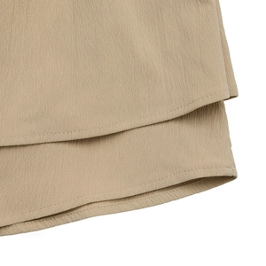 Detail of khaki tiered skirt hem showing crinkled texture and double stitching