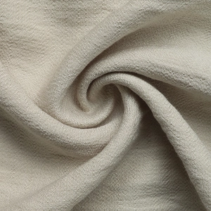 Detailed macro view of beige linen-blend fabric with natural woven texture and soft drape