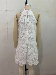 Detail of adjustable bow tie and backless design on white crochet lace halter dress