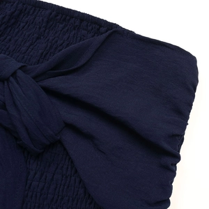 Détail de la taille smockée bleu marine avec un nœud décoratif sur la combinaison