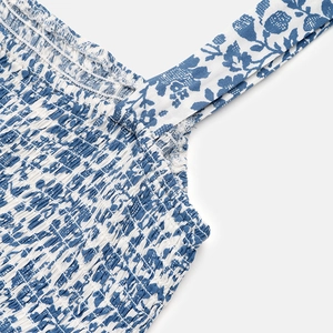 Detail of floral smocking bodice and wide shoulder straps on a blue summer dress