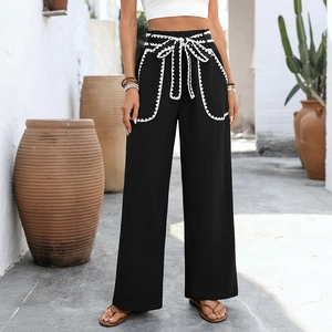High-waisted black wide-leg trousers with white wave trim and bohemian waist tie