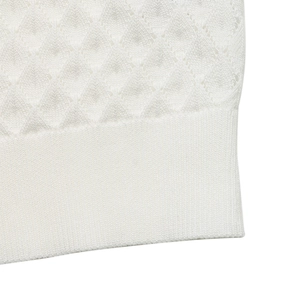 Détail du motif en tricot losange blanc et de l'ourlet côtelé de ce vêtement d'été
