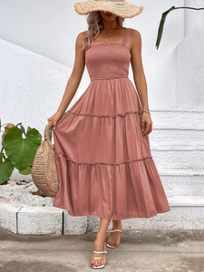 Pink tiered midi dress with square neck and smocked bodice in an outdoor setting