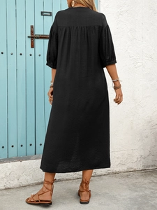 Close-up of black bohemian dress with detailed pleated texture and ethnic style accessories
