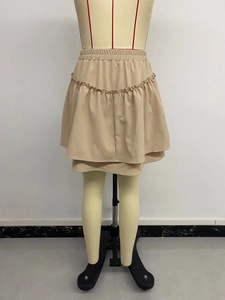 Detail of light beige tiered mini skirt with elastic waist and ruffled chiffon texture