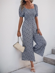 Detail of blue floral romper featuring square neck, puff sleeves and wide leg design