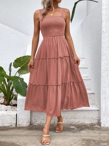 Detail of smocked elastic bodice and tiered skirt on a rose pink summer midi dress
