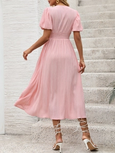Détail de la robe midi rose à taille smockée avec manches bouffantes et texture
