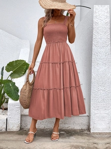 Detail view of the smocked bodice and tiered dusty rose midi dress for summer vacation