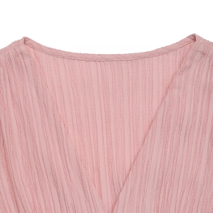 Gros plan détaillé du décolleté en V rose avec texture plissée sur robe d'été