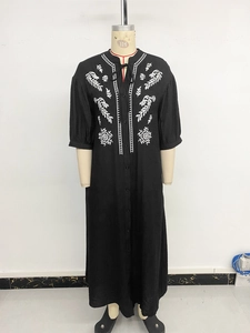 Detail view of ethnic embroidery on a black bohemian maxi dress with long split hem