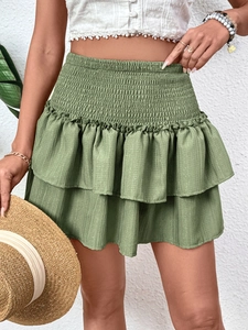 Close-up of green tiered ruffle mini skirt featuring high waist and textured fabric