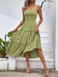 Detail of smocked bodice and tiered maxi skirt on a grass green summer dress