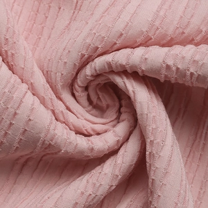 Détail de la robe rose à manches bouffantes montrant le tissu plissé et le jacquard doux