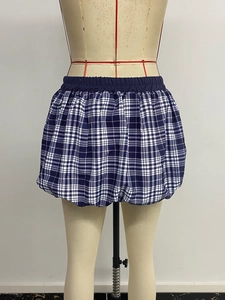 Detail of navy blue plaid puff skirt featuring elastic waistband and voluminous hem