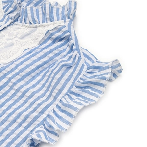 Detailed view of the blue striped shirt with white lace collar and ruffle trim accents