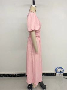 Détail d'une robe midi rose à manches bouffantes et texture plissée verticale