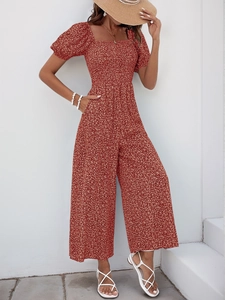 Detail of red floral summer jumpsuit featuring smocked bodice and square neckline