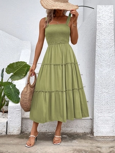 Detail of tiered avocado green summer dress with smocked bodice and square neckline