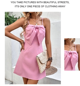 Detail of the oversized pink bow on a backless mini dress with elegant texture