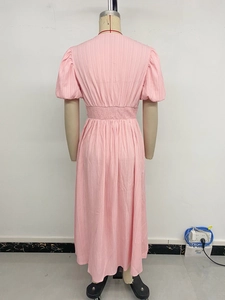Détail du dos d'une robe midi rose à manches bouffantes en tissu gaufré avec taille élastique
