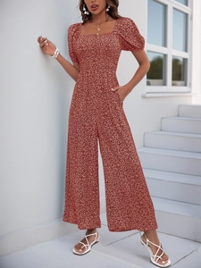 Detail view of red floral jumpsuit with square neck, puff sleeves and wide leg design