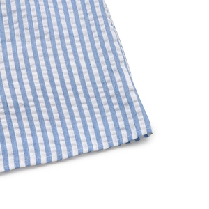 Detail shot of blue and white striped seersucker fabric with neat hem stitching