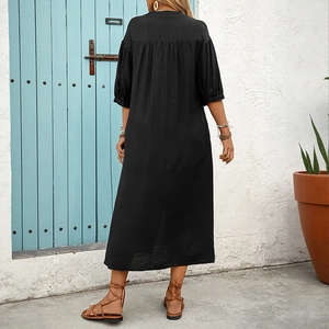 Back view of a black ethnic style loose maxi dress with five-point sleeves in a garden