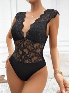 Detailed close-up of exquisite floral lace patterns and deep V-neckline on a black bodysuit