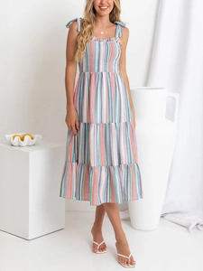 Détail d'une robe midi à rayures colorées avec bretelles à nœuds et jupe à volants