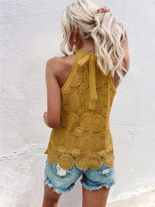 Close-up of mustard yellow lace halter top featuring floral cutout details and back tie bow