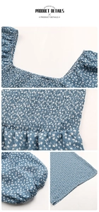Detail view of smocked square neckline and white floral print on blue puff sleeves