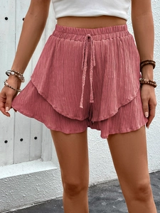 Detailed texture of high-waisted cotton shorts with drawstring and double ruffle hem