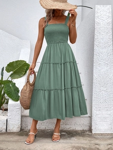 Detail of green smocked tiered maxi dress with thin straps for summer vacations