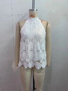 Detail of white floral lace halter neck top with intricate hollow-out embroidery