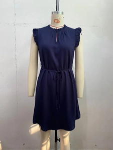 Détail d'une robe sans manches bleu marine avec épaules volantées et cordon à la taille
