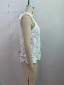 Detail of white crochet sleeveless top featuring floral lace patterns and high neck cut