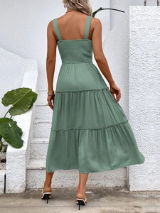 Back view of a sage green tiered summer dress with smocked bodice and wide straps